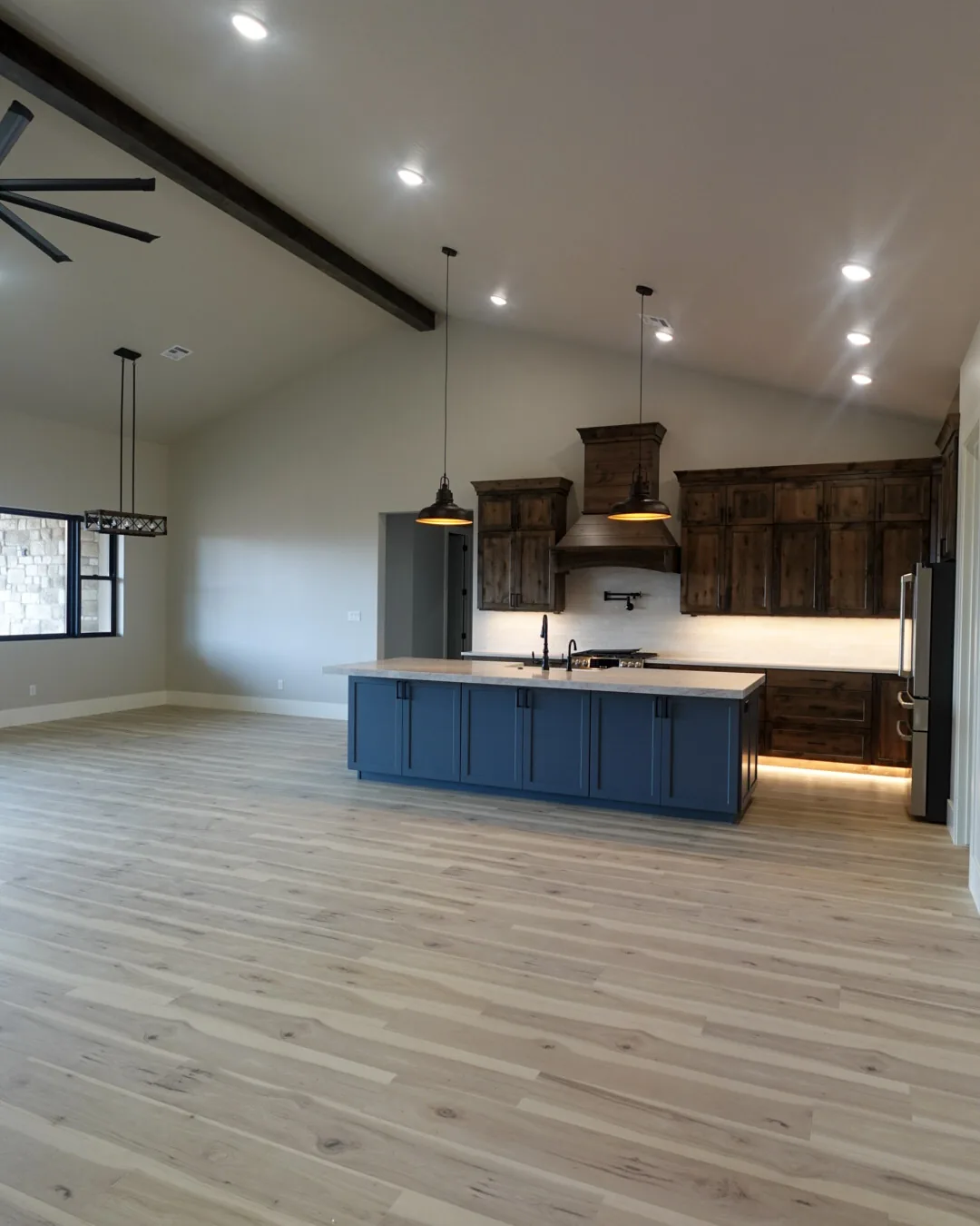 Vaulted great room with an exposed beam opening onto the kitchen