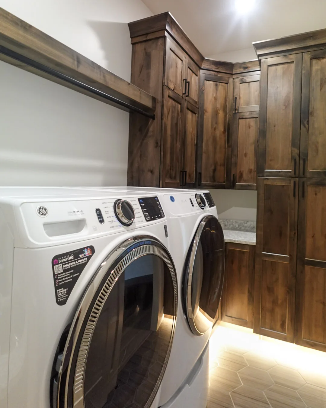Laundry room with alder cabinetry and herringbone tile flooring