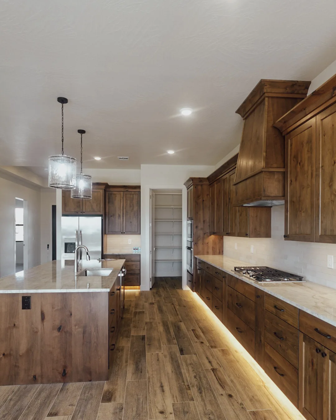The Holloway, a custom home by Elevated Construction, kitchen with a custom wood hood and alder cabinetry