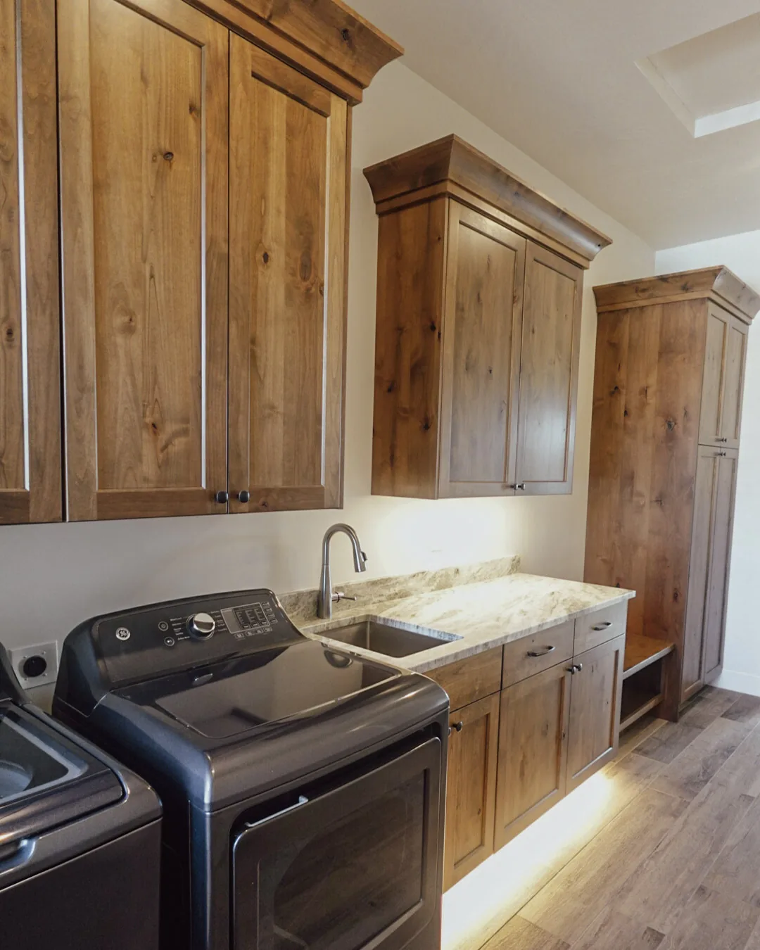 Laundry room with alder cabinetry, a sink, and a folding counter