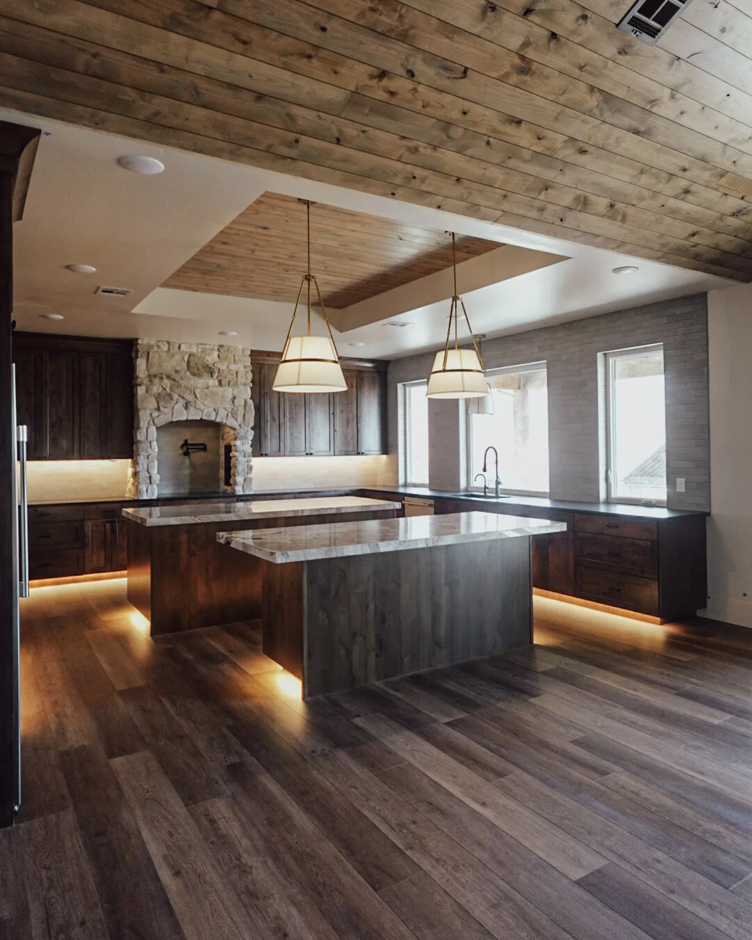 Open kitchen with a planked tray ceiling, pendant lighting, and a long island