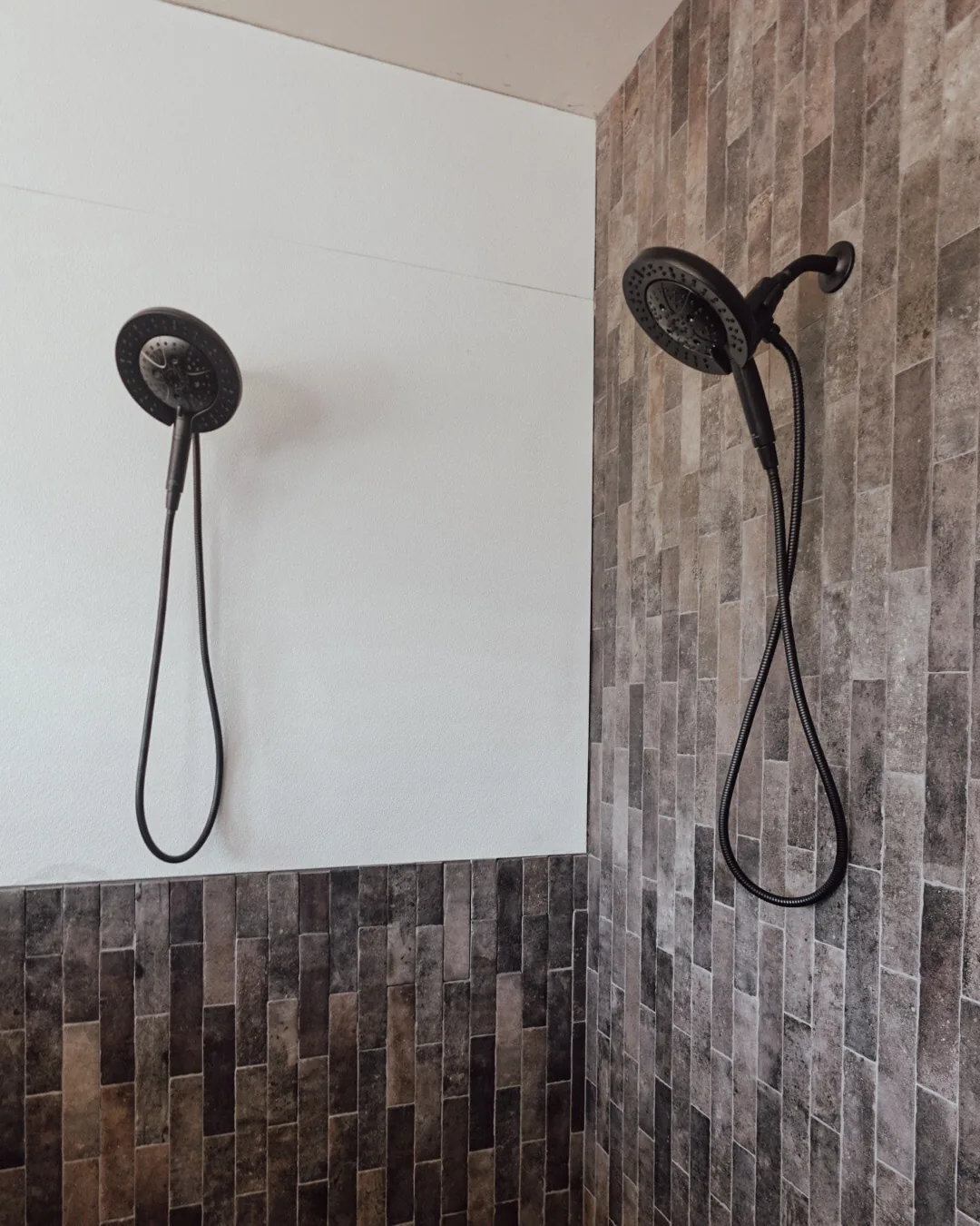 Walk-in shower with dual heads and stacked stone tile
